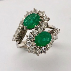 AN EMERALD AND DIAMOND CROSSOVER RING