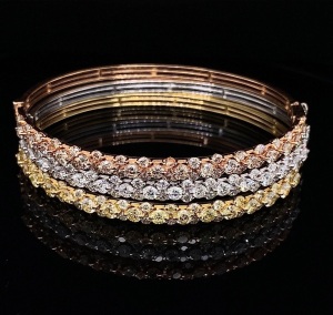 A COLOURED AND WHITE DIAMOND TRIO OF HINGED BANGLES