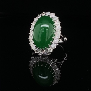 A CABOCHON JADE AND DIAMOND CLUSTER RING