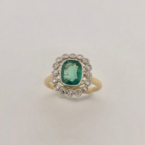 AN EMERALD AND DIAMOND CLUSTER RING