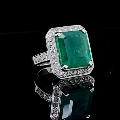 AN EMERALD AND DIAMOND CLUSTER RING