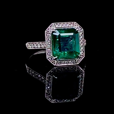 AN EMERALD AND DIAMOND CLUSTER RING