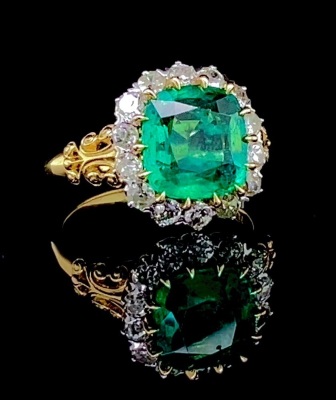 AN EMERALD AND DIAMOND CLUSTER RING