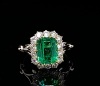 AN EMERALD AND DIAMOND CLUSTER RING