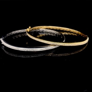 A PAIR OF GOLD AND DIAMOND HINGED BANGLES
