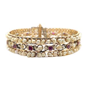 AN ANTIQUE INDIAN NATURAL PEARL AND RUBY BANGLE