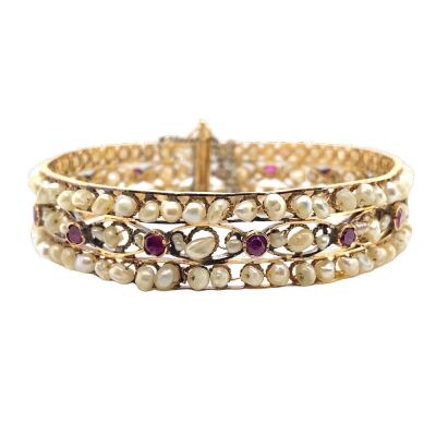 AN ANTIQUE INDIAN NATURAL PEARL AND RUBY BANGLE